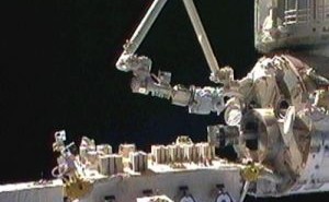 Główny japoński manipulator wyciąga ramię SFA ze śluzy, po środku widoczna paleta z eksperymentami EF / Credits: spacefellowship.com