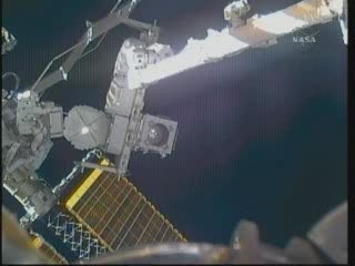 Przenosiny czwartej baterii (astronauci po prawej stronie tego ujęcia) / Credits - NASA TV Przenosiny czwartej baterii (astronauci po prawej stronie tego ujęcia) / Credits - NASA TV