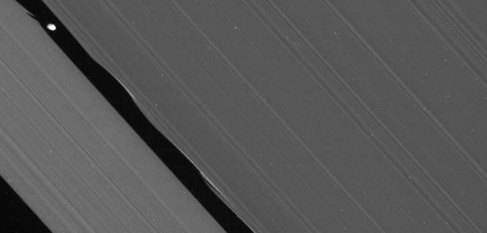 Nieprocesowane zdjęcie przedstawiające księżyc Daphnis wewnątrz przerwy Keeler'a w pierścieniu A; obraz wykonano za pośrednictwem filtrów CL1 oraz CL2 - od ultrafioletu do bliskiej podczerwieni; wersja poddana obróbce zostanie opublikowana dopiero w przyszłym roku (NASA/JPL/Space Science Institute)
