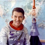 Astronauta Wally Schirra pozuje do zdjęcia w swoim skafandrze Navy Mk IV; w tle widoczna kapsuła Mercury (NASA/S62-05526)