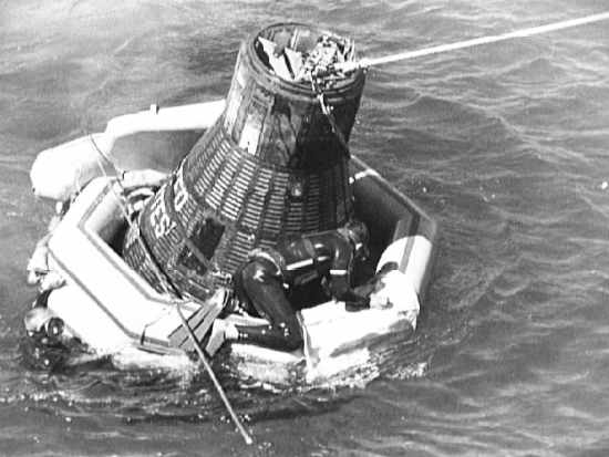 Płetwonurek Marynarki sprawdza stan kapsuły i stan mocowania liny holowniczej (NASA/S62-06160)