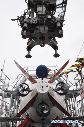 Zdjęcie wykonano 1 lipca 2011 roku. Przedstawia podwodny okręt Jiaolong, ładowany na Xiangyanghong 09, naukowy statek badawczy. Załadunku dokonano w porcie miasta Jiangyin, w prowincji Jiangsu, we wschodniej części Chin. Jiaolong rozpoczyna swoją podróż, w trakcie której zanurzy się na głębokość 5000 metrów, kontynuując zeszłoroczne testy, w trakcie których osiągnął granicę 3579 metrów. [Credits: Xinhua]