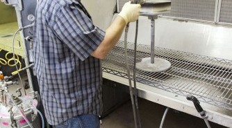 Technik Frank Pelkey, (z United Space Alliance w Centrum Kosmicznym Kennedy'ego NASA na Florydzie), w trakcie pracy nad płytką mającą stać się częścią osłony termicznej Oriona. Znajdzie się ona w tylnej części prototypowej kapsuły. (Photo credit: NASA/Frankie Martin)