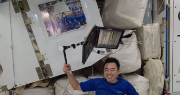 Japończyk Aki Hoshide obok plakatu przesłanego w kapsule Dragon. Zdjęcie z 14 października 2012 / Credits - NASA
