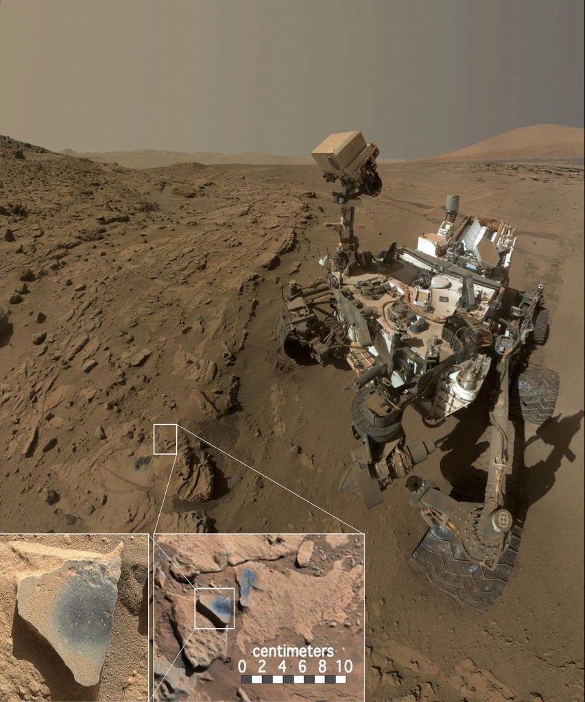 Łazik Curiosity badający formację Kimberley w kraterze Gale na Marsie. Przed łazikiem widoczne są dwa otwory wywiercone przez instrument do pobierania próbek i kilka ciemniejszych punktów, które zostały oczyszczone z pyłu. Źródło: MSSS/JPL/NASA