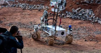 Polski łazik z nietypowymi, obrotowymi kołami wykonanymi w technologii druku 3D z wypełnieniem w formie plastra miodu, co czyni je lekkimi oraz bardzo twardymi - robot zmierza do tablicy z przełącznikami podczas jednej z konkurencji / Credits - Marcin Szustak
