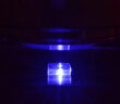 Pobudzany światłem niebieskim kryształ fluorku litu z zarejestrowanymi śladami cząstek jonizujących podczas obserwacji pod mikroskopem fluorescencyjnym. (Źródło: IFJ PAN)